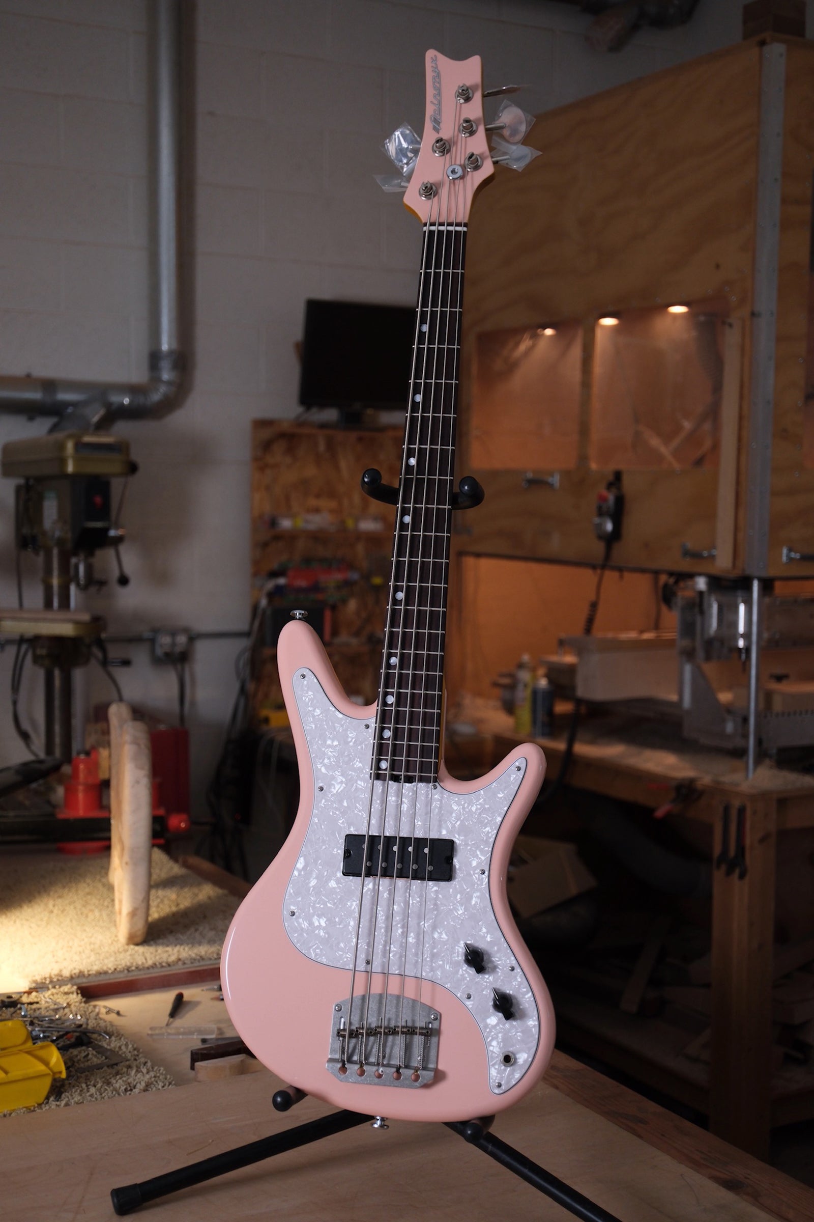 full front photo of the Acinonyx V Short Scale Bass Guitar - Shell Pink showing the matching pink headstock