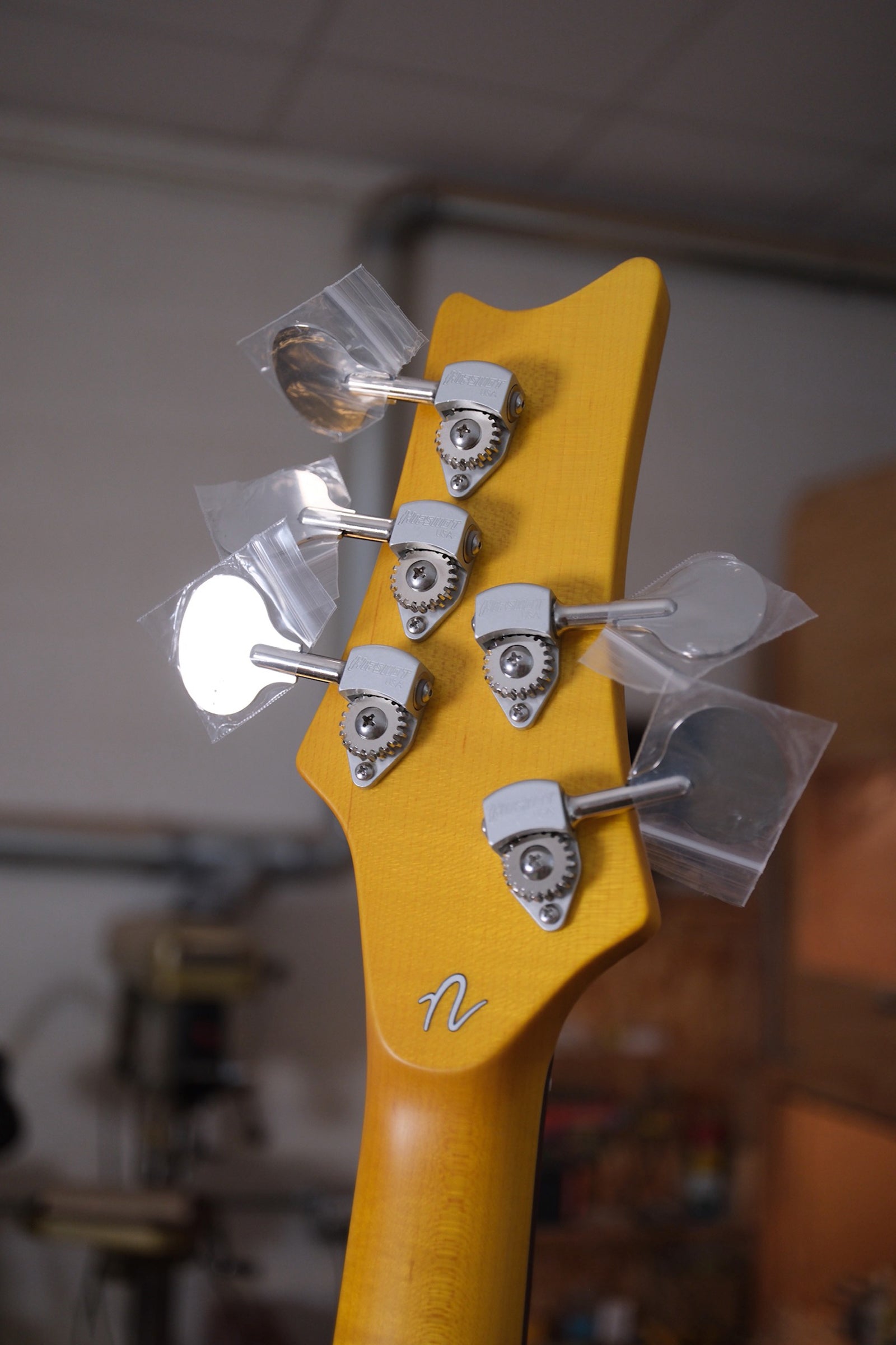 photo of the back of the headstock of the Acinonyx V Short Scale Bass Guitar - Shell Pink showing the lollipop tuning machines