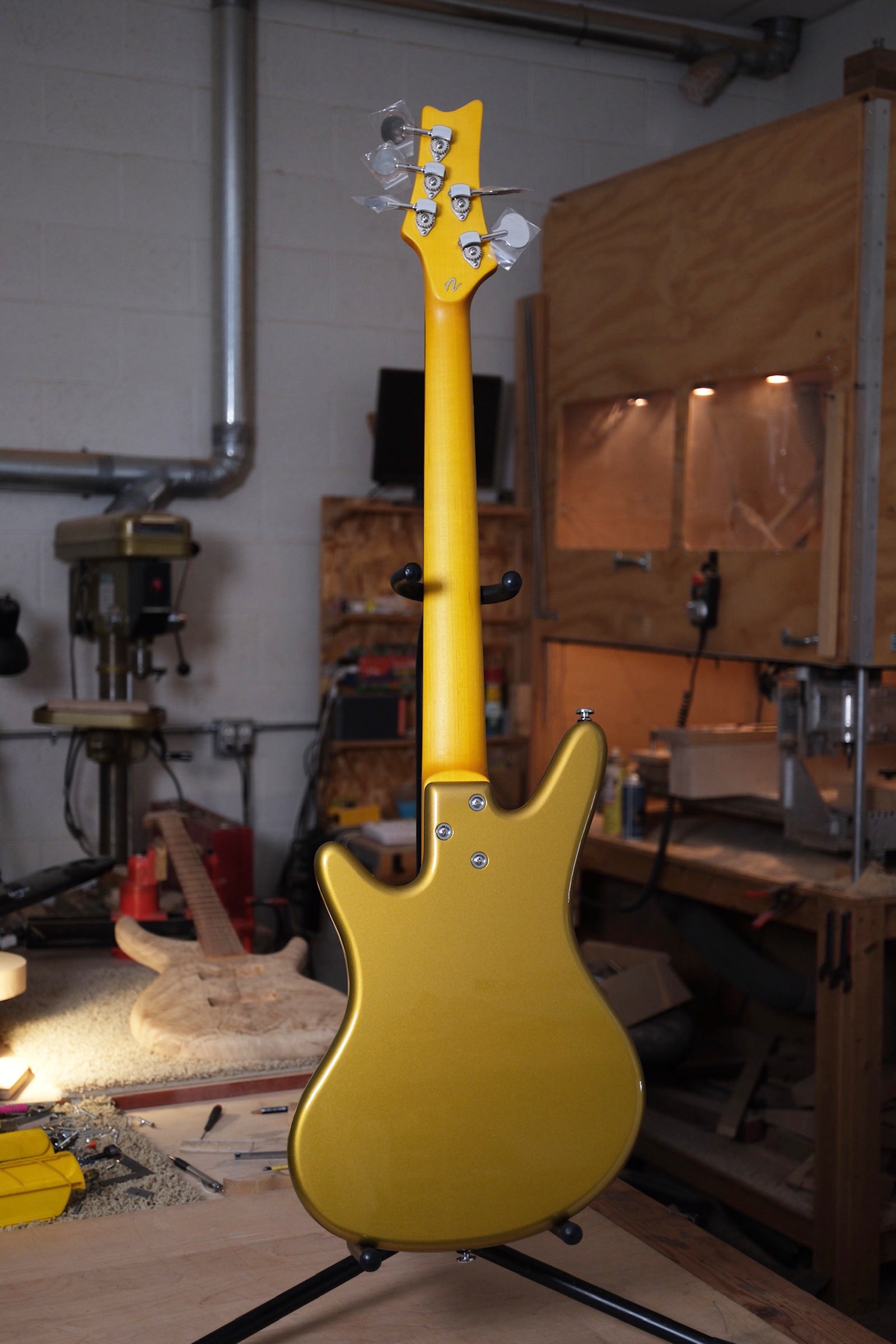 photo of the back side of the Acinonyx V Short Scale Bass Guitar - Aztec Gold showing the 3 bolt connection and the back of the hipshot tuners