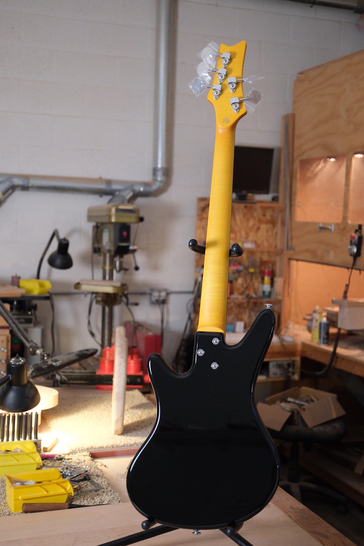 full body shot of the Acinonyx V Short Scale Bass Guitar - Black shot from the back showing the maple neck