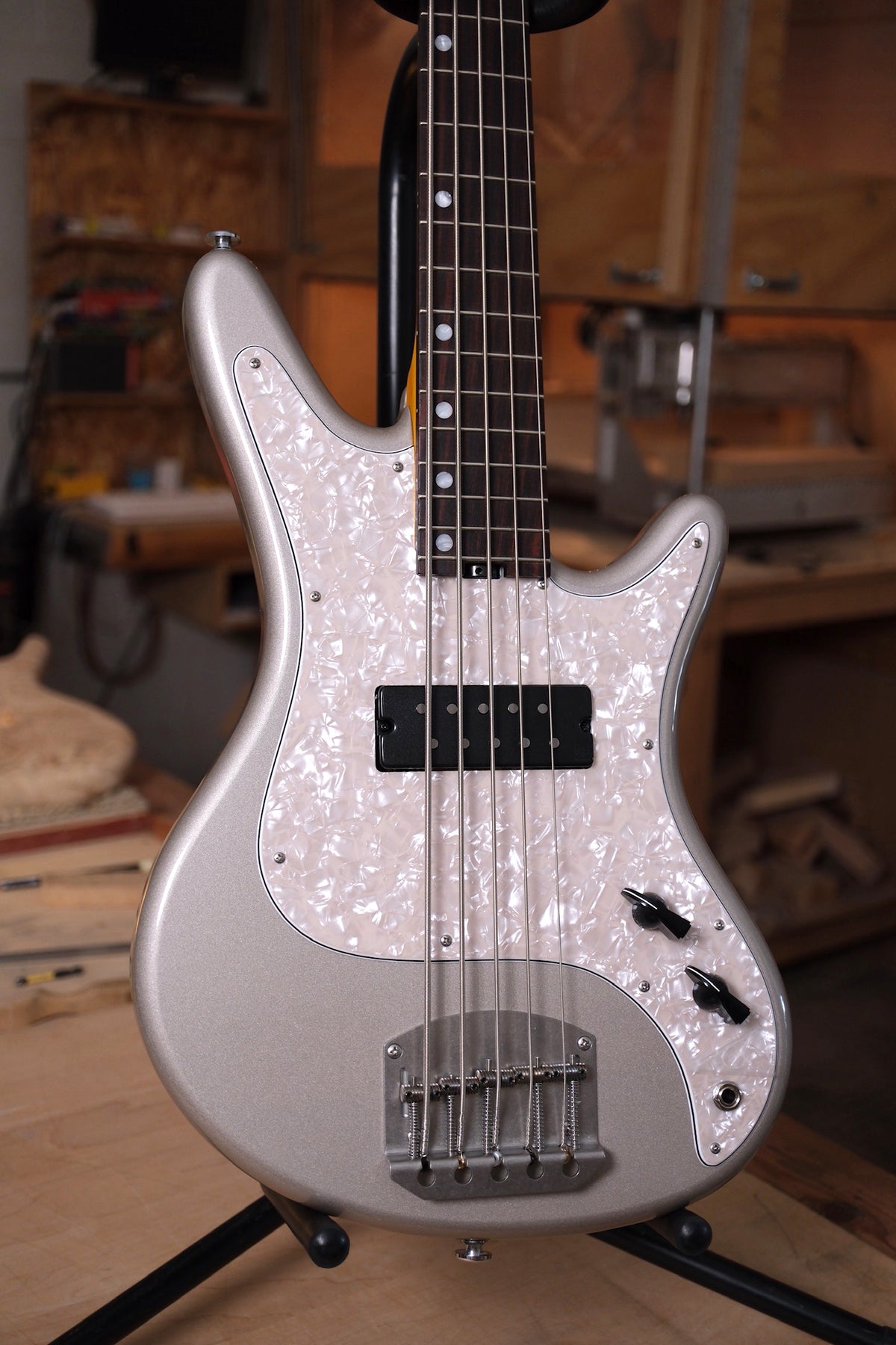photograph of the body of the Acinonyx V Short Scale Bass Guitar - Inca Silver showing the pearloid pickguard, and two chicken head knobs