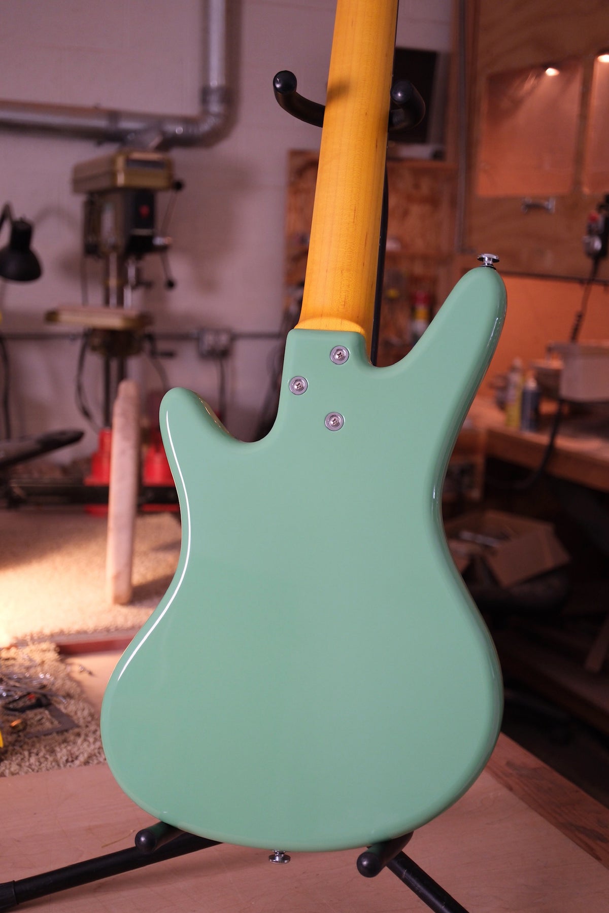 Back body photo of the Acinonyx V Short Scale Bass Guitar - Seafoam Green showing the 3 whole mounting pattern