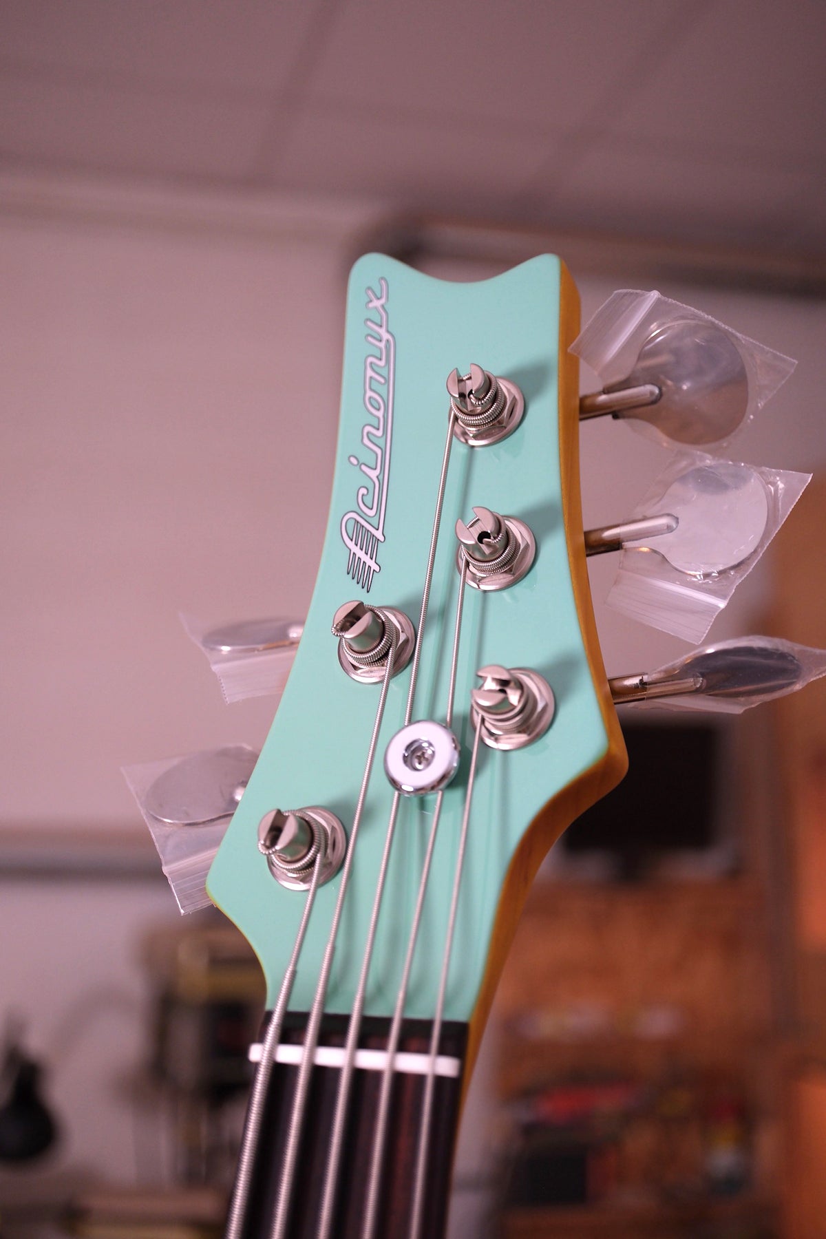 photo of the front of the headstock of the  Acinonyx V Short Scale Bass Guitar - Seafoam Green showing the 2x3 tuning machine layout