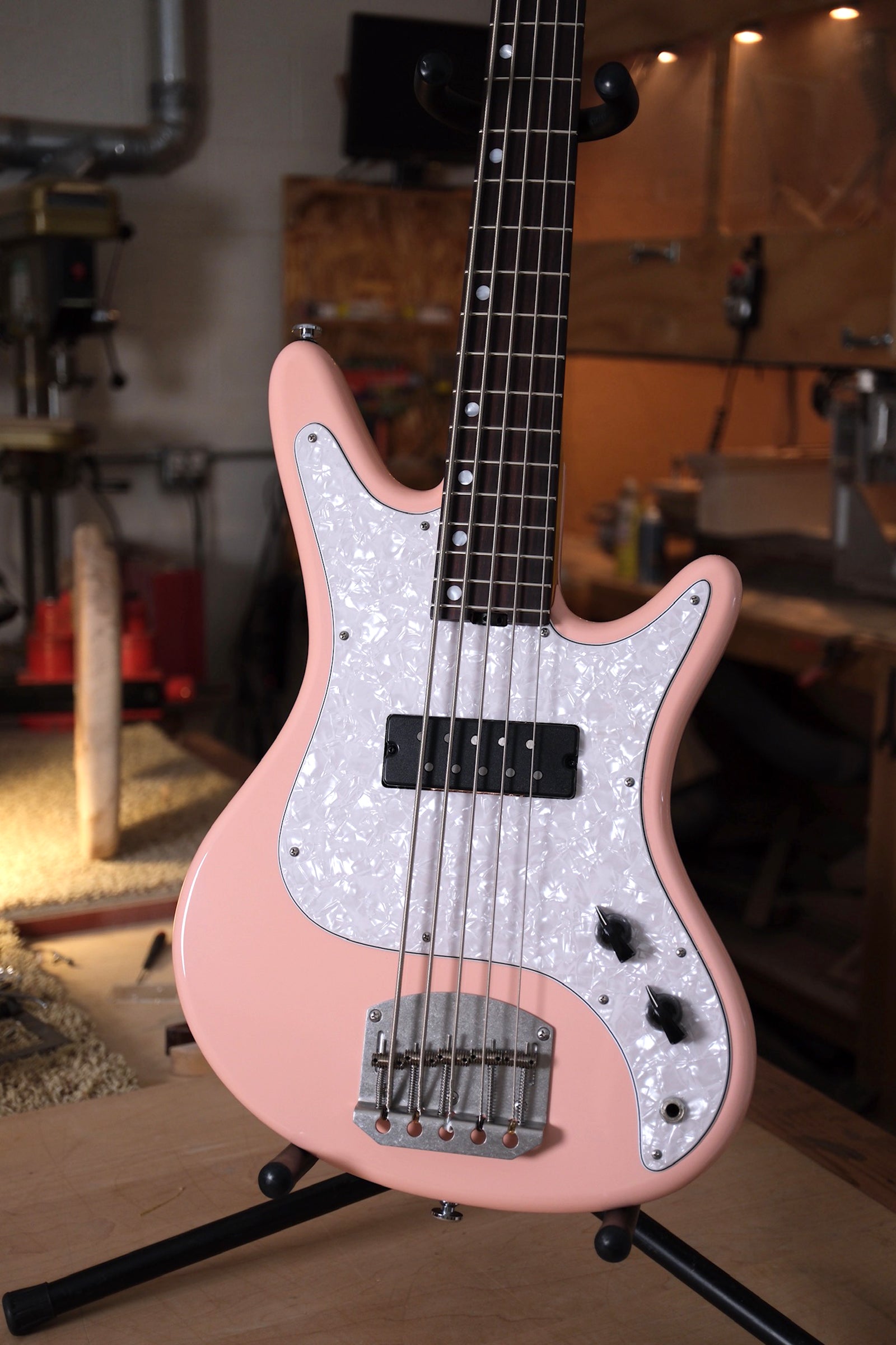 front image of the Acinonyx V Short Scale Bass Guitar - Shell Pink showing the pearloid pickguard 